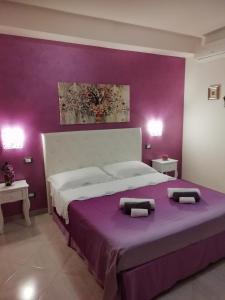una camera da letto con un grande letto con pareti viola di Da Luigi locazioni brevi turistiche a Monopoli