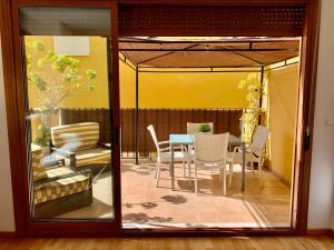 een glazen deur naar een patio met een tafel en stoelen bij Palau de Palomar - PalomarGroup in Valencia