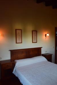 a bed in a bedroom with two pictures on the wall at Amaicha Apartamentos Rurales in Ribadesella