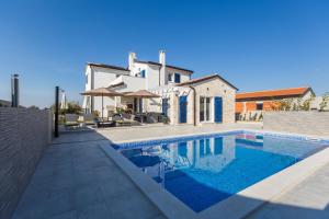 a villa with a swimming pool in front of a house at Villa Camelia in Tar
