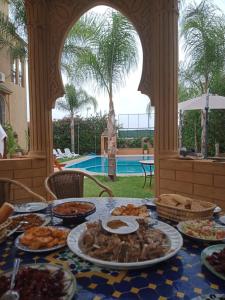 une table avec des assiettes de nourriture au-dessus dans l'établissement Les Jardins de Ryad Bahia, à Meknès