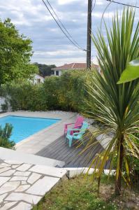 een patio met een stoel naast een zwembad bij Chez Phil et Dom in Biarritz