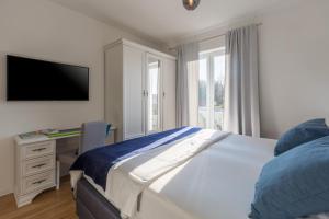 a bedroom with a bed and a desk with a television at Villa Camelia in Tar +58 photos