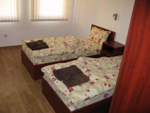 StoykiteにあるKrasi Apartments in Zornitsa Complexのベッドルーム1室(花の飾られたベッド2台付)