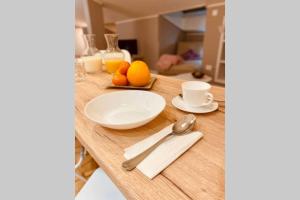 巴爾巴斯特羅的住宿－Mi Pequeña Buhardilla，一张桌子上放着盘子,勺子和橙子