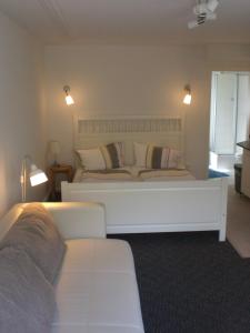 a bedroom with a large white bed and a couch at Zur Weide in Boltenhagen