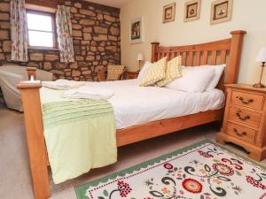 a bedroom with a bed with a wooden headboard at Usherwoods Barn in Lancaster