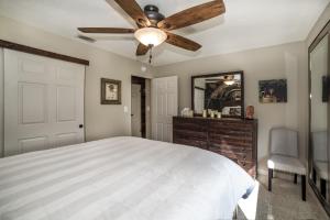a bedroom with a bed and a ceiling fan at Gulfport Beach Vacation Rental in St Petersburg