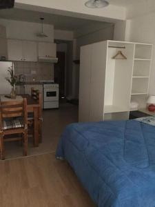 1 Schlafzimmer mit einem blauen Bett und einer Küche in der Unterkunft Excelente monoambiente in Neuquén