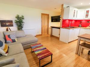 a living room with a couch and a kitchen at Redwood in Harlech