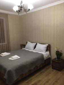 een slaapkamer met een bed met twee handdoeken erop bij Guest house Babaka in Sighnaghi