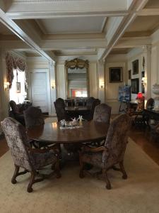 Burke Mansion في ماكون: غرفة معيشة مع طاولة وكراسي خشبية
