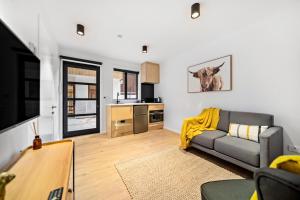uma sala de estar com um sofá e uma cozinha em Stylish Brand New Apartment - 7 Minute walk to Town em Queenstown