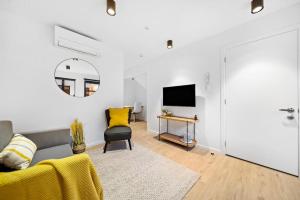 uma sala de estar com um sofá e uma televisão em Stylish Brand New Apartment - 7 Minute walk to Town em Queenstown