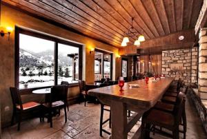 un comedor con una gran mesa de madera y sillas en Vitina House, en Vitina