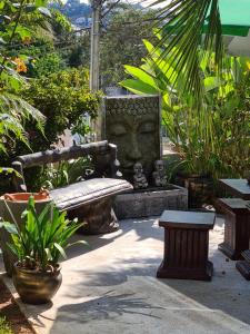 a stone bench in the middle of a garden at Pousada Lugama in Bento Gonçalves