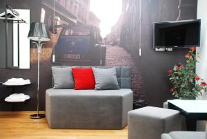 a couch with a red pillow on a street at Black & White in Kraków