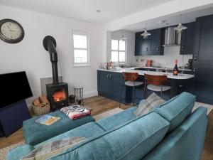 a living room with a blue couch and a kitchen at 126 Main Street in Keighley
