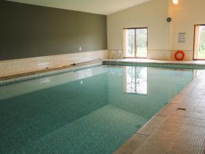 an empty swimming pool with green tiles on the floor at Oak Lodge in Hadnall