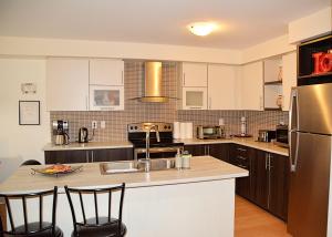 a kitchen with white cabinets and a stainless steel refrigerator at Quiet and Beautifull Home in Niagara Falls