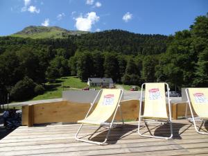 - deux chaises sur une terrasse avec vue sur la montagne dans l'établissement Auberge La Soulan, à Boutx