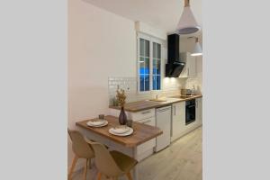 eine Küche mit einem Holztisch und Stühlen in der Unterkunft Studio cosy refait à neuf,au calme 5 min du centre in Angers