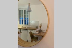 einen Spiegel in einer Küche mit einem Tisch und einem Stuhl in der Unterkunft Studio cosy refait à neuf,au calme 5 min du centre in Angers