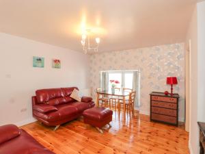 - un salon avec un canapé et une table dans l'établissement Shetland Cottage, à Dalbeattie