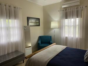 a bedroom with a bed and a blue chair at Hideaway on Hume in Boonah