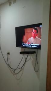 TV de pantalla plana colgada en la pared en Hotel El Puerto en Tolú