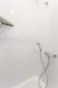 La salle de bains est pourvue d'une douche avec un tuyau. dans l'établissement Studio with amazing view - Hrekivska str. 5-2, à Kharkov