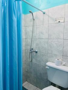 y baño con ducha con cortina azul. en Hostel Trotamundos en San Juan