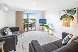 a living room filled with furniture and a large window at The Observatory Self Contained Apartments in Coffs Harbour