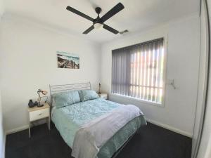 1 dormitorio con 1 cama y ventilador de techo en Lovely Modern 3br 2bth Beachside suburb Home en Largs