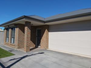 a brick house with a white garage at Lovely Modern 3br 2bth Beachside suburb Home in Largs