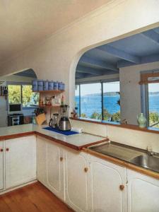 a kitchen with white cabinets and a view of the ocean at The Shack in Southport