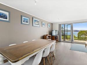 uma sala de jantar com uma grande mesa e cadeiras em Apartment 29 Pacific Apartments em Lorne