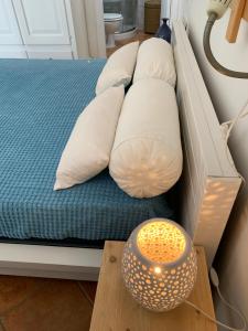 a bed with white pillows and a table with a lamp at B&B Casavecchia in Gallipoli