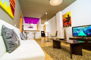 salon z białą kanapą i telewizorem w obiekcie Apartamentos 16:9 Suites Almería w mieście Almería