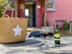 Mizra Guest House في Mizra‘: طاولة مع كأسين من النبيذ وحقيبة