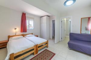 Mizra Guest House في Mizra‘: غرفة نوم بسرير كبير وأريكة زرقاء