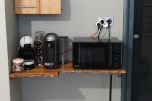 a counter with a microwave and other items on it at Le gîte des sources: nature, randonnées, détente. in Oberbronn