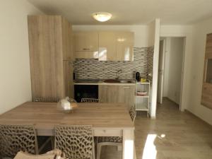 una cucina con tavolo in legno in una camera di Baby House Calasetta - IUN P5263 a Calasetta