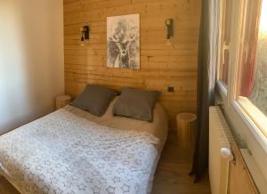 um pequeno quarto com uma cama e uma janela em LA PERLE DES CAILLOUX EXCEPTIONNEL et COSY em Font Romeu Odeillo Via