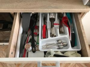a drawer filled with utensils in a cabinet at Familienapartment am Strand in Primorsko in Primorsko