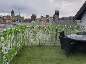 a fence covered in ivy with a table and chairs at Central Windermere Luxury two bed Apartment Dog Friendly in Windermere