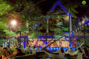 a group of people sitting at a restaurant at night at Makofi Guest House in Nungwi