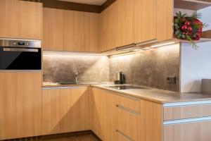 a kitchen with wooden cabinets and a sink at Ulrica - Apartment Kristyn in Ortisei