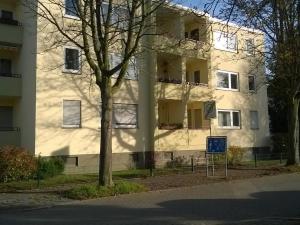 un bâtiment blanc avec un arbre devant lui dans l'établissement Fewo Neukirchen mit Balkon, à Neukirchen-Vluyn