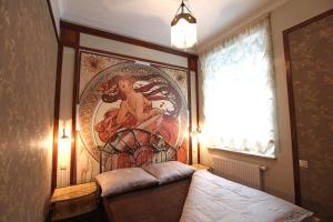 a bedroom with a painting on the wall next to a bed at Apartamenty Klejnot Sopotu in Sopot